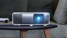 BenQ TK710STi projector on stand in living room