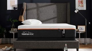 The Tempur-Pedic Tempur-ProAdapt mattress on a gray bed frame against a dark gray wall