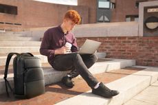 College student sitting on steps with coffee and Dell Laptop