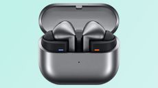 Leaked images of the Samsung Galaxy Buds 3 charging case. The case is black and the earbuds are black. Teal background