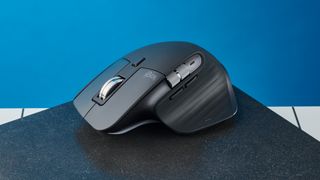 A photo of the Logitech MX Master 3S on a black slate against a blue background.