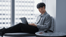 man using laptop on a windowsill